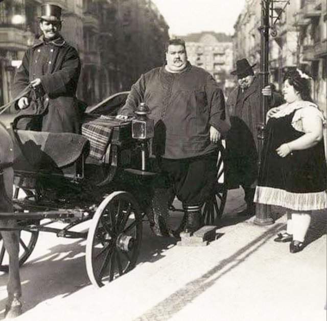 Мужчина (вес 284 кг) со своей женой (вес 174 кг) собирается на прогулку в конной коляске. Германия, 1912 год.