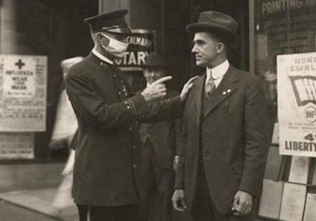 Полицейский в Сан-Франциско делает предупреждение мужчине за то, что он не носит маску во время пандемии гриппа, 1918 год.
