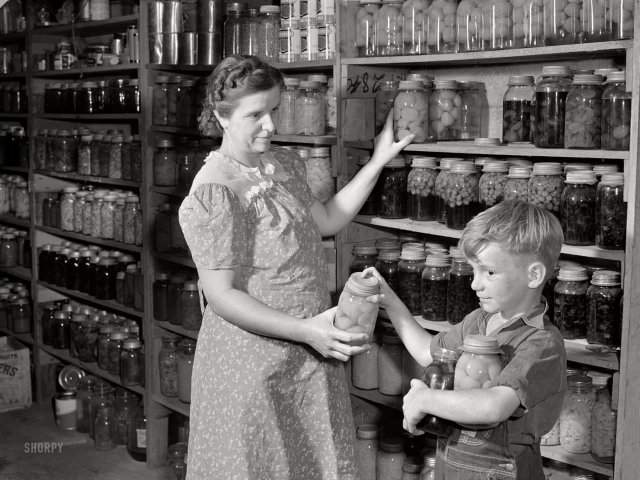 Миссис Харви Реннингер с сыном в своем холодном хранилище консервов. Ватерлоо, Небраска. Сентябрь 1941 года.