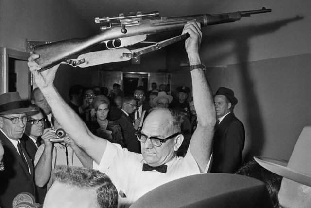 Полицейский Далласа держит винтовку, из которой, по версии следствия, был убит Джон Кеннеди. 1963 год