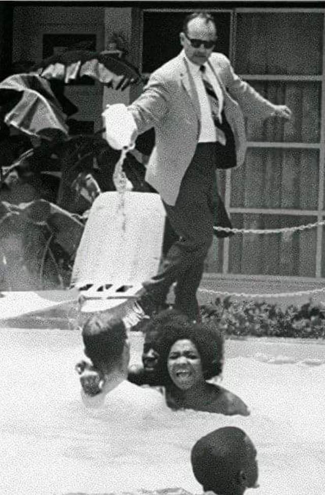 Менеджер отеля льёт отбеливатель в бассейн, в котором плавают чернокожие. США, 1964 год