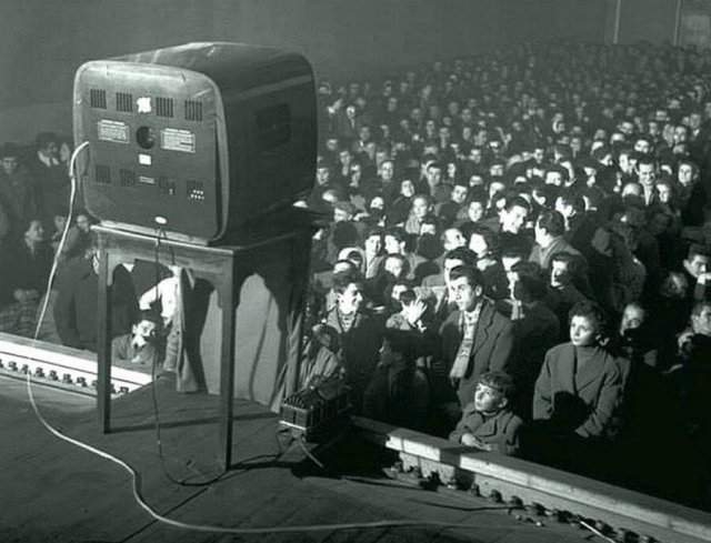Люди в кинотеатре смотрели фильмы, демонстрируемые по телевизору. 1956 год