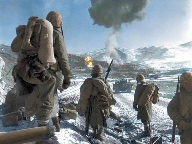 Солдаты морской пехоты США наблюдают за напалмовой бомбардировкой китайских позиций. 26 декабря 1950 года.