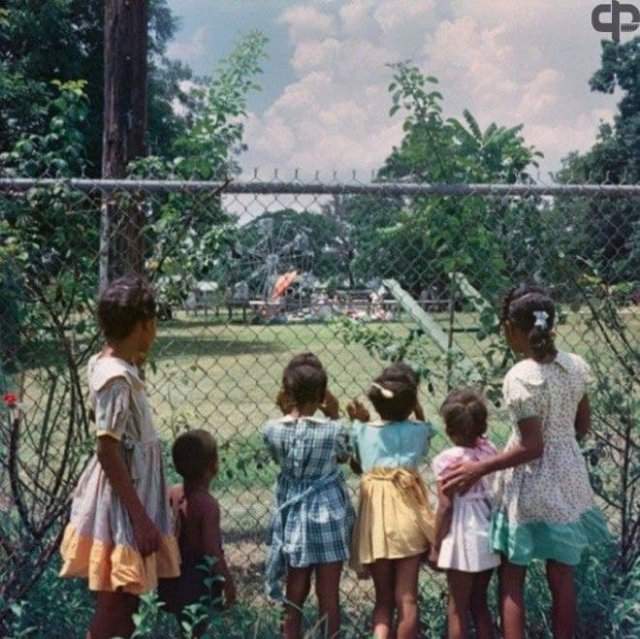 Темнокожие дети у забора детской площадки “только для белых”, Алабама, 1956г.