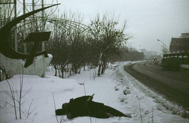 Уставший от употребления портвейна мужчина, лежит на обочине зимней дороги. Новокузнецк, 1994 год.