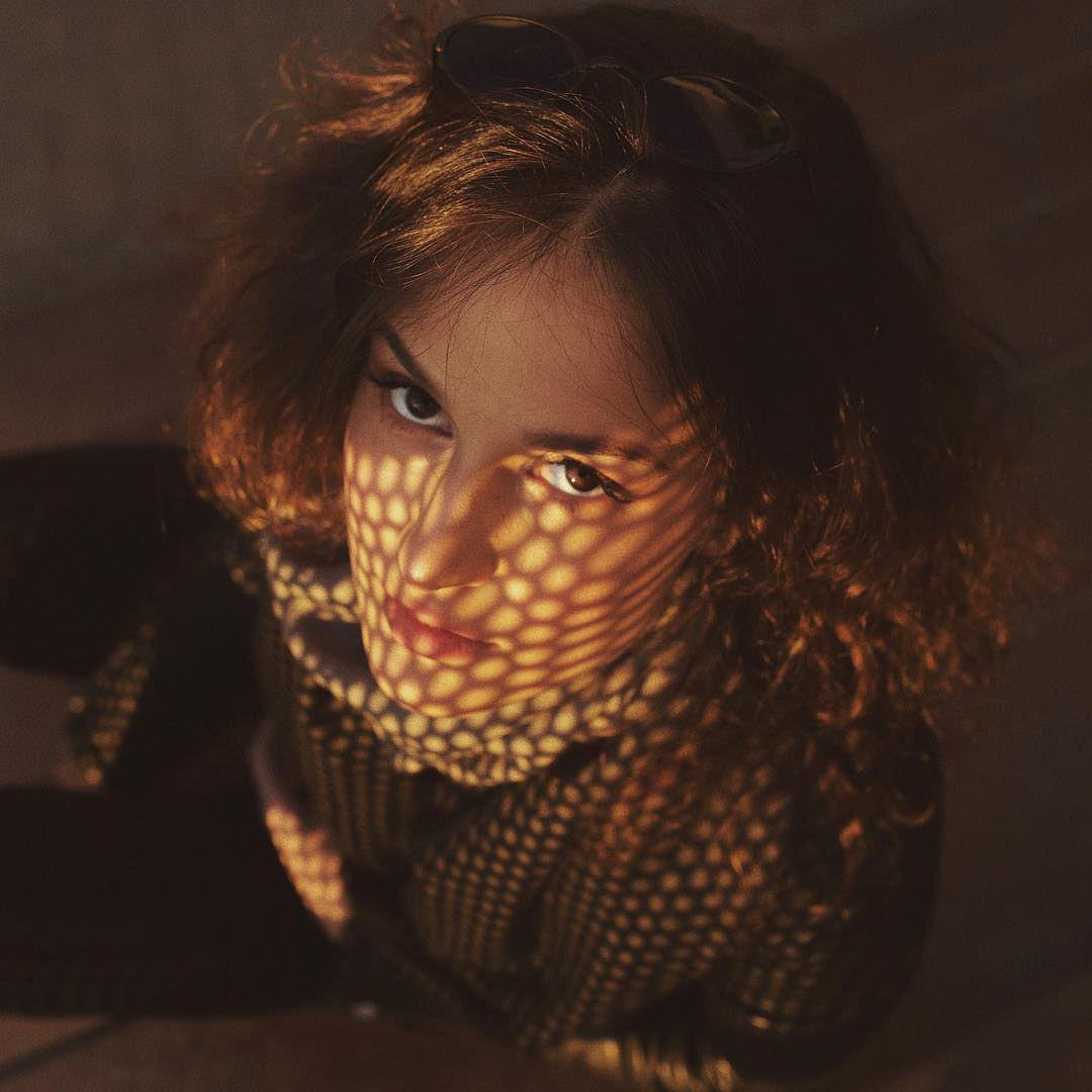 Валерия Демидова в темной сетчатой кофте с тенью на лице