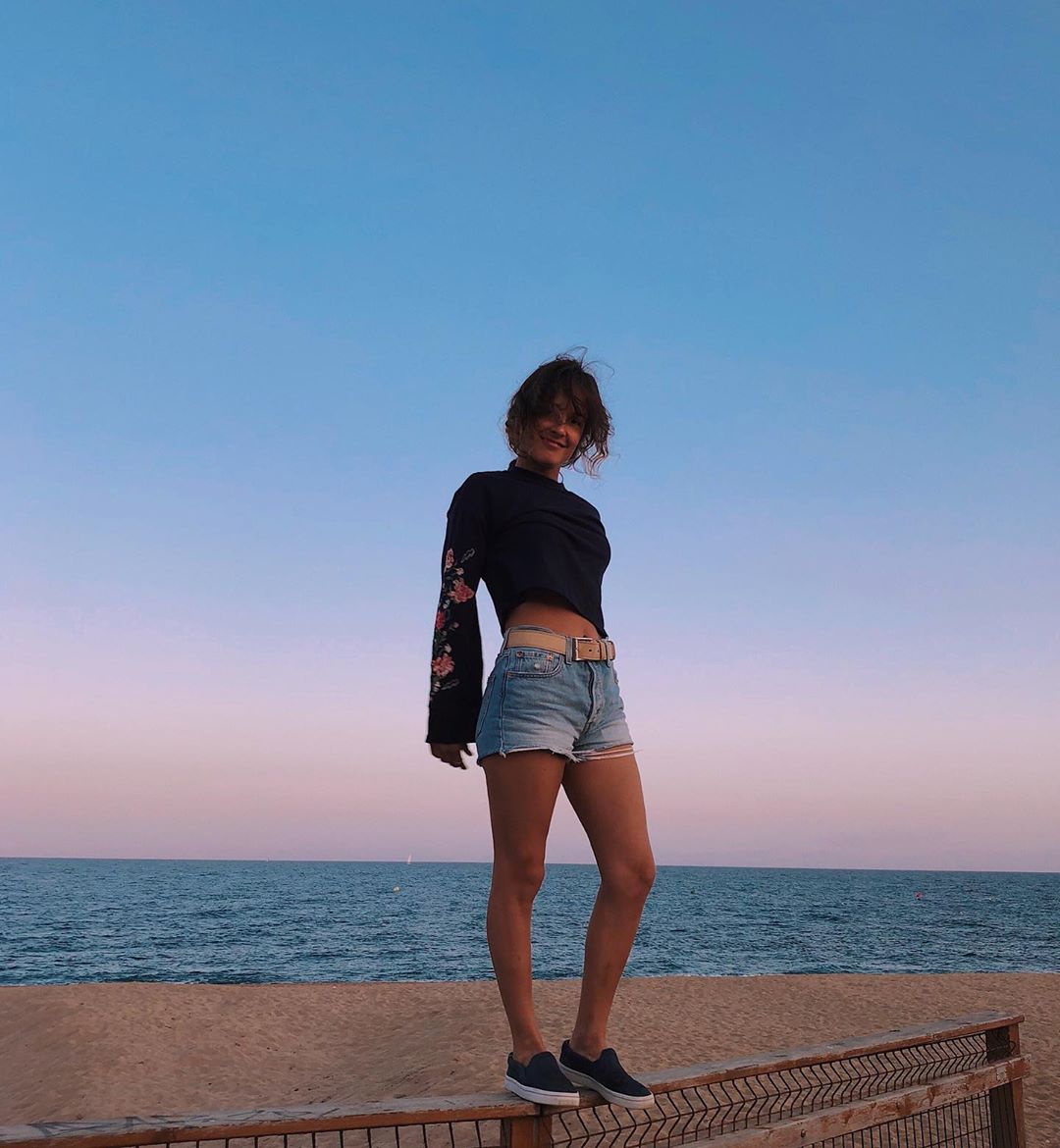 Валерия Демидова позирует на пляже в черной кофте, джинсовых шортах и кроссовках