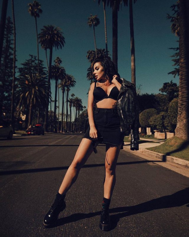 Юлия Волкова в черной одежде на фоне пальм в Лос-Анджелесе