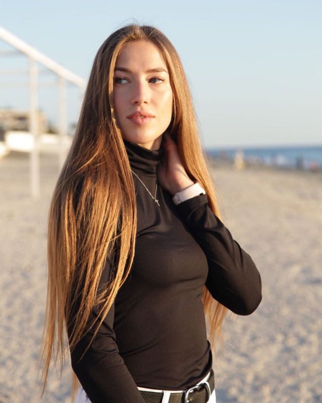 Виктория Морозова на пляже в черной кофте