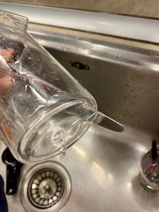 Парень мыло посуду, когда его нож пробил стекло