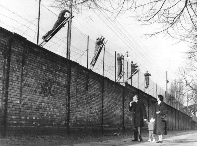 Пограничники Восточного Берлина увеличивают высоту берлинской стены с помощью колючей проволоки. Германия, 19 ноября 1961 года.