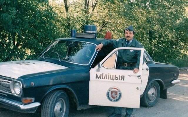 Белорусский милиционер рядом со своей патрульной Волгой