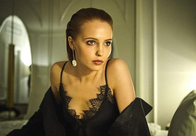 Юлия Хлынина в черном платье на кровати