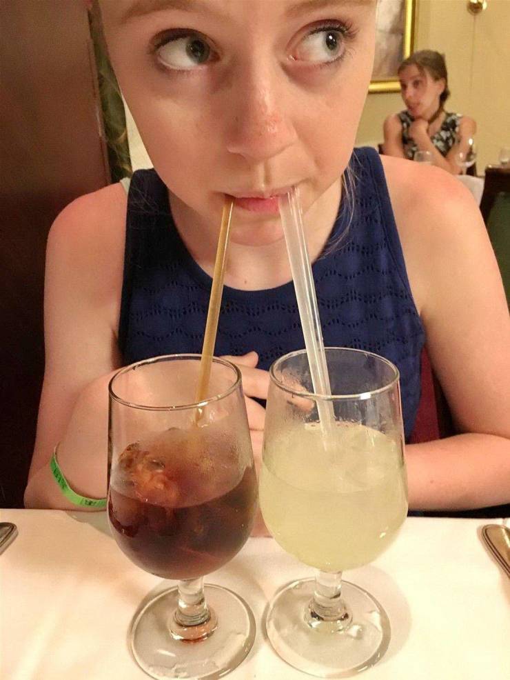 Девушка пьет из двух бокалов