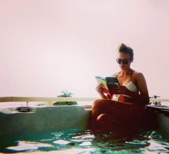 Бри Ларсон в купальнике читает книгу