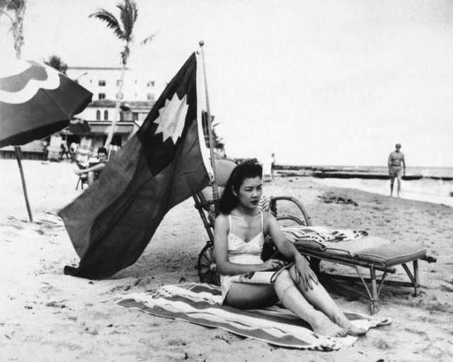 Китаянка Руфь Ли загорает под китайским флагом, чтобы её не перепутали с японкой, декабрь 1941 года, США