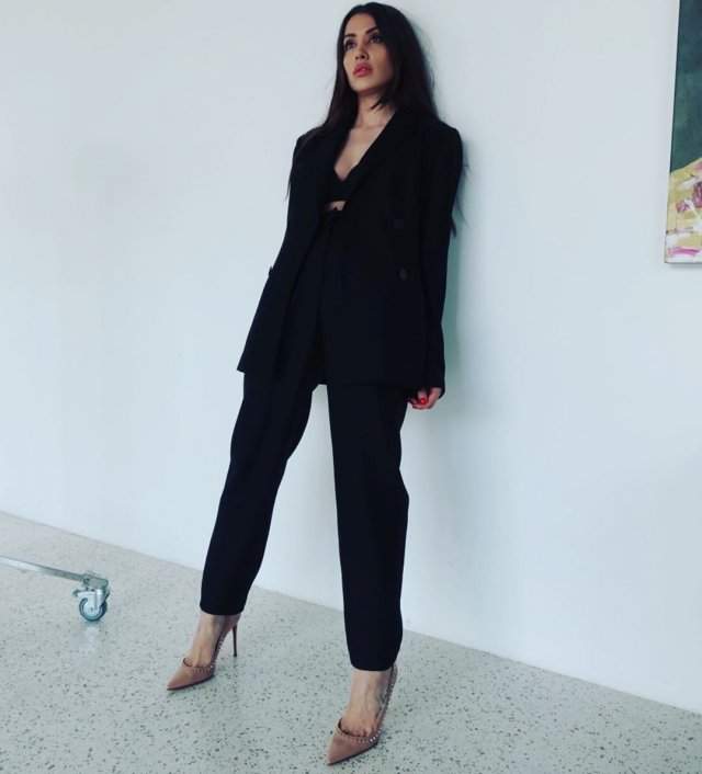 Новая девушка Ильи Прускина из Little Big - Ксения Красовская в черном пиджаке и брюках у стены