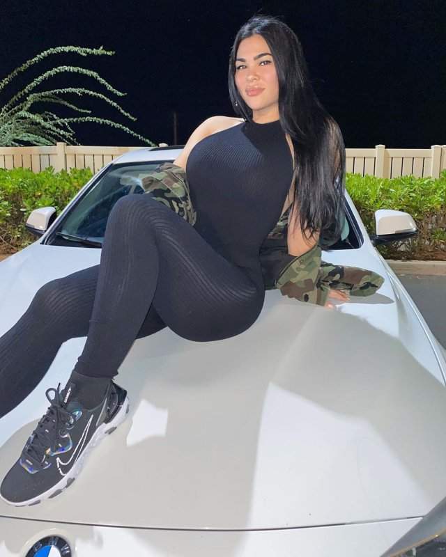 Рэйчел Остович в черной одежде на капоте машины