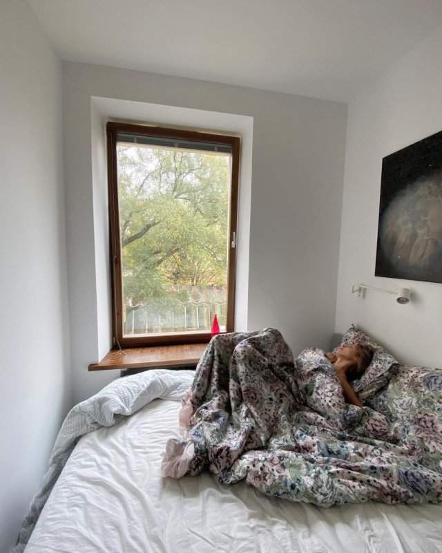 Марина Кацуба под одеялом на фоне окна