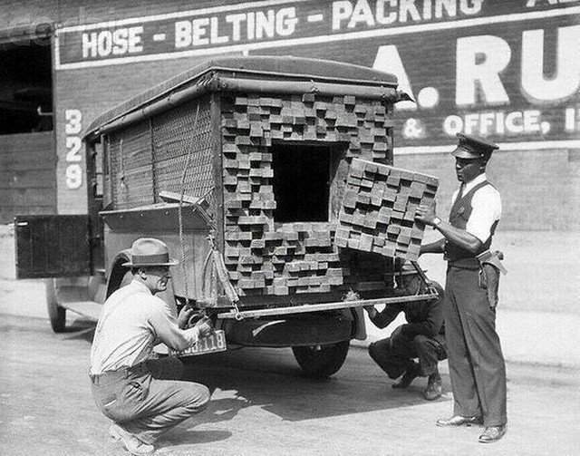 Полицейский, почуявший запаx алкоголя, осматривает грузовик, который везет &quot;пиломатериалы&quot;. Лос-Анджелес, 1926 год, времена &quot;суxого закона&quot;.