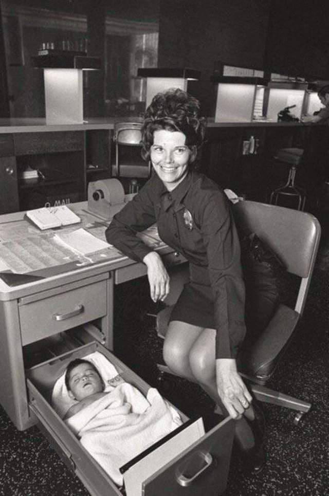 Женщина-полицейский присматривает за брошенным младенцем, бережно уложив его в ящике своего стола. Лос-Анджелес, 1971 г.