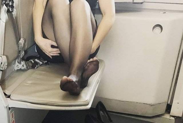 Женские ноги в колготках в самолете