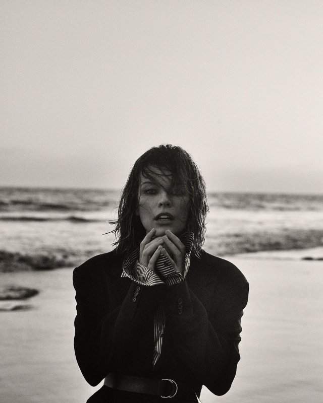Милла Йовович в черном платье на пляже