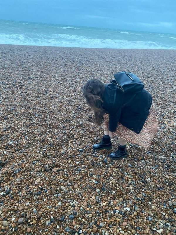 Юбка девушки сливается с камнями на берегу