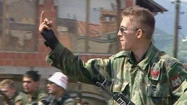 Югославский солдат показывает средний палец американским миротворцам