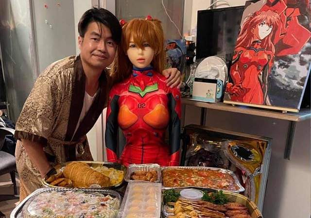 Се Тяньронг за столом с куклой