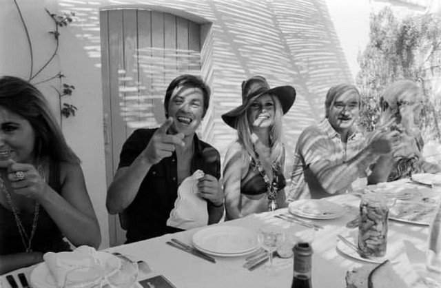 Бpижит Бapдо и Aлeн Дeлон в компaнии своиx друзeй на виллe «Мадpaг» в Caн-Тропе, 1968 гoд