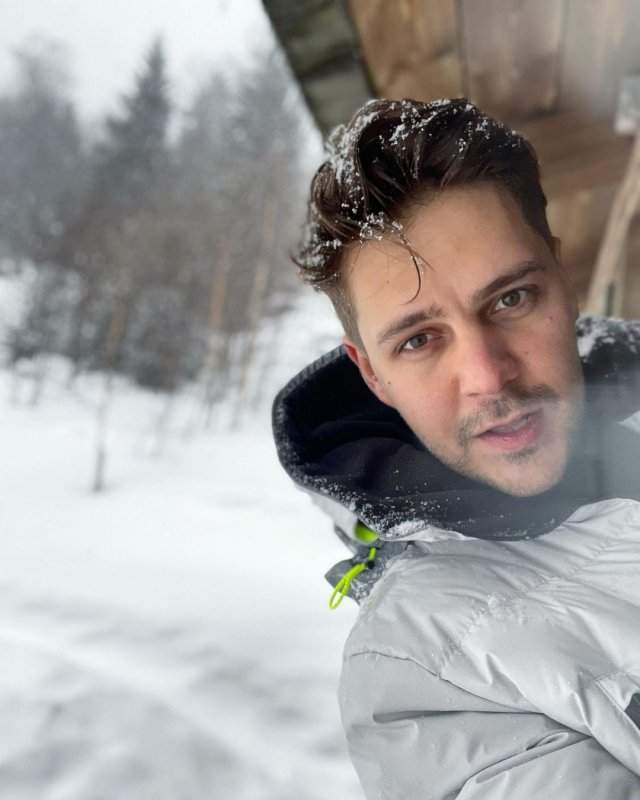 Милош Бикович в горах в белой куртке