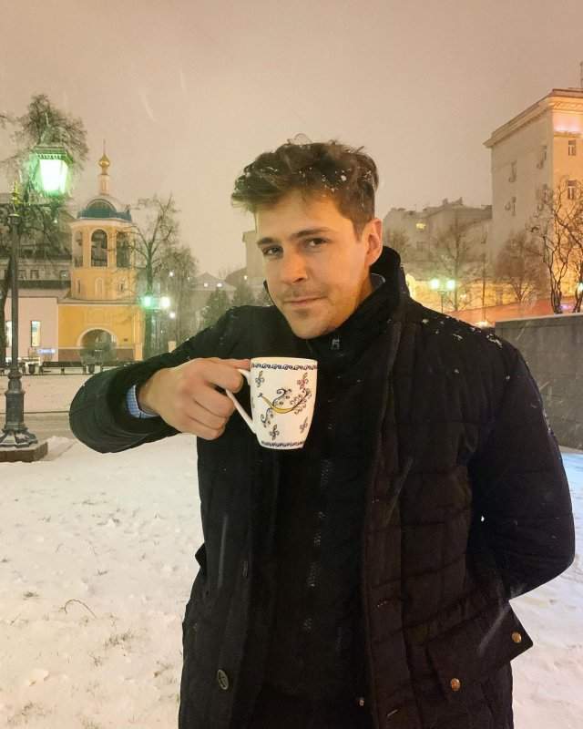 Милош Бикович на фоне церкви с чашкой