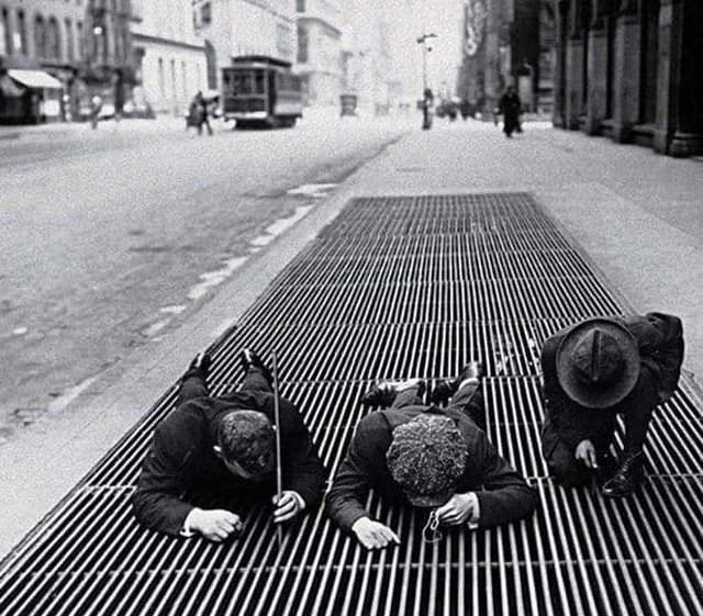 Мальчишки вылавливают мелкие монетки из вентиляционной решетки в Нью-Йорке во время Великой Депрессии, 1930 г.