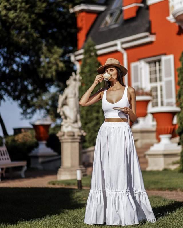 Алана Мамаева в белом платье на фоне дома