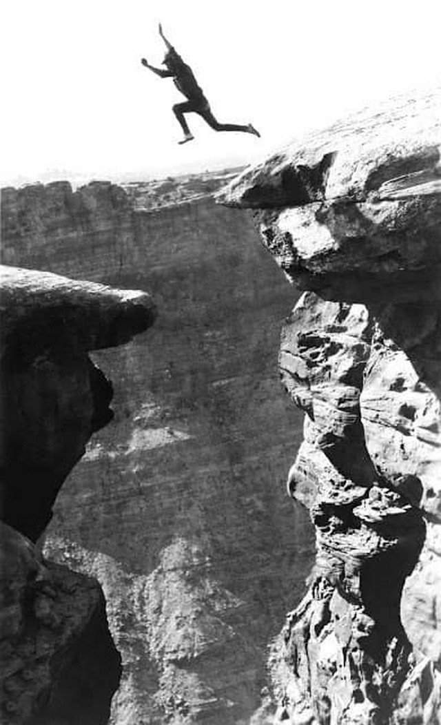 Мужчина прыгает с одного уступа на другой в Гранд-Каньоне, 1900-е.