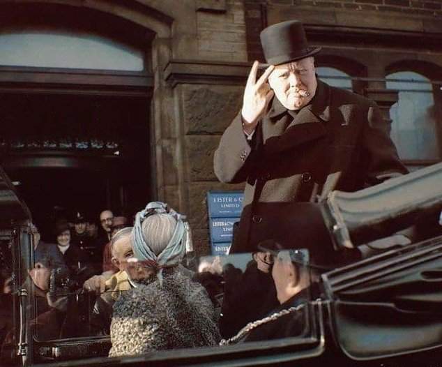 Уинстон Черчилль с сигарой во рту показывает знак &quot;V&quot; во время визита в Брэдфорд. 4 декабря 1942 года.