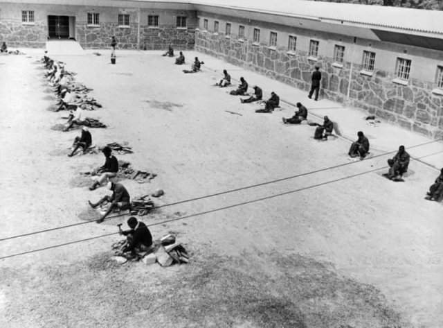 Заключенные дробят булыжники и шьют тюремную одежду. Роббенэйланд. ЮАР. 1964 год.