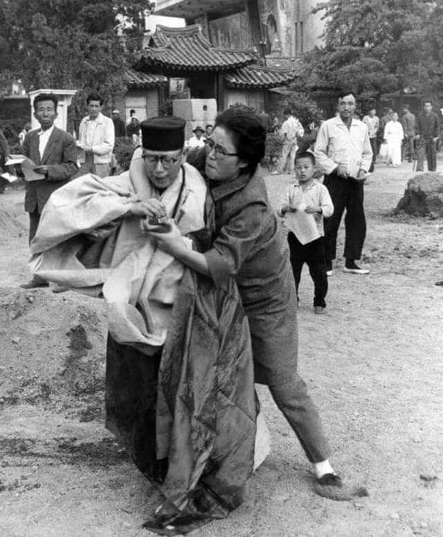 Женщина вырывает спички у буддийской монахини, облившей себя бензином. Южная Корея, 1963 год.