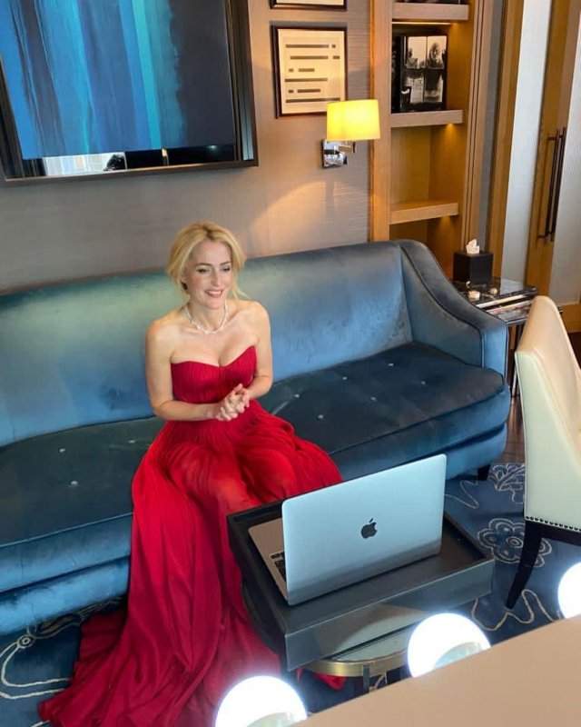 Джиллиан Андерсон, звезда сериала &quot;Секретные материалы&quot; в красном платье перед ноутубком на диване