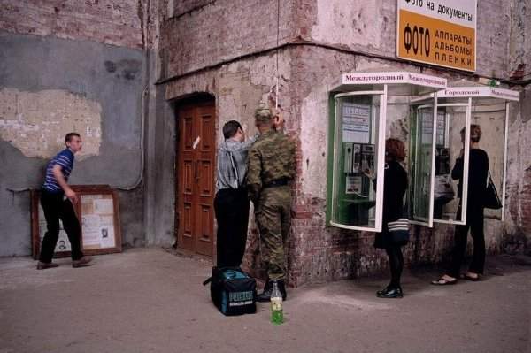 Люди звонят с уличного телефона на Балтийском вокзале. Россия, Санкт-Петербург, 1997 год.
