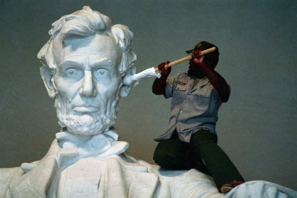 Рабочий чистит ухо статуе Авраама Линкольна