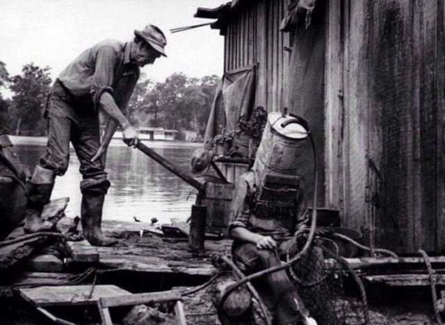 Ловец жемчуга на Миссисипи готовится к очередному &quot;заходу&quot;. В качестве шлема - старый топливный бак от автомобиля. В нем он мог погружаться на глубину до 21 метра и быть под водой до 1,5 часа, 1938 год
