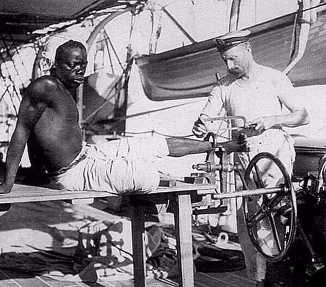 Британский моряк снимает кандалы с раба. Великобритания. Конец 19-го века.