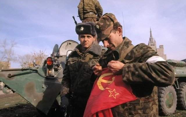Офицер Таманской дивизии рвёт снятый с Белого дома советский флаг. 1993 год, октябрь.