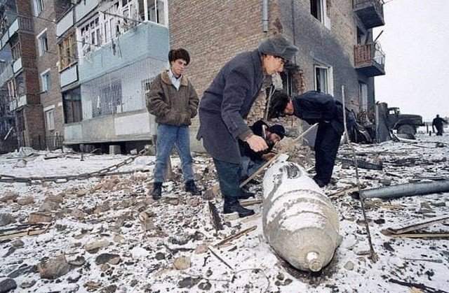 Чеченцы осматривают неразорвавшуюся бомбу после налета российской авиации на Аргун, 24 декабря 1994 года.