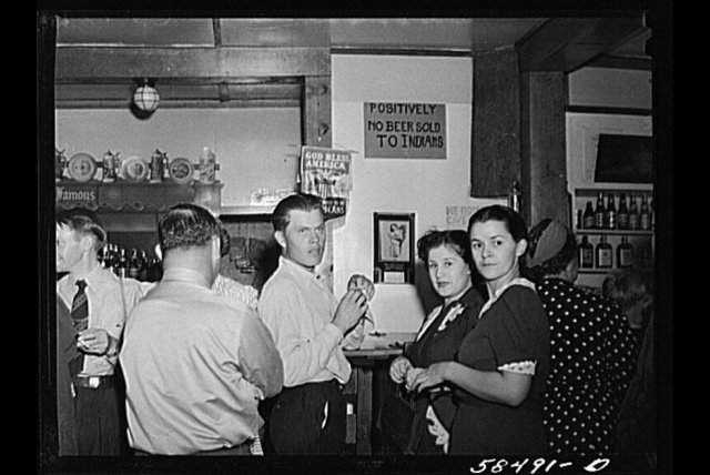 Обычный американский бар 1941 года, в котором висит табличка, что пива индейцам тут не наливают.