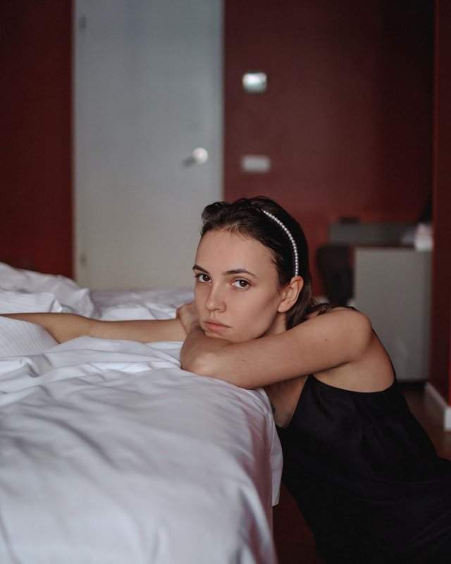 Девушка Саши Петрова Стася Милославская в черном платье на кровати
