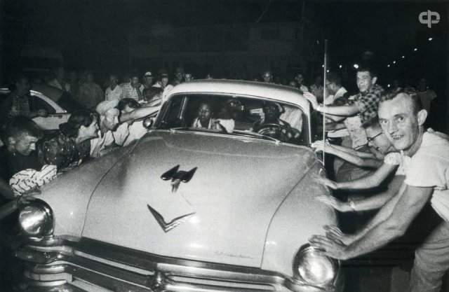 Толпа пытается перевернуть автомобиль с темнокожей семьей во время расовых беспорядков в г.Клинтоне. Теннесси. США. 1956 г.