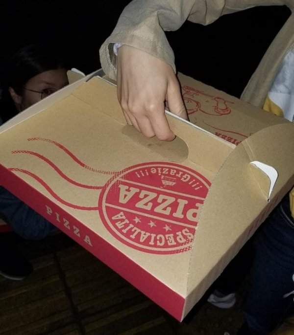 У коробки для пиццы есть ручка, которая позволяет нести пиццу горизонтально